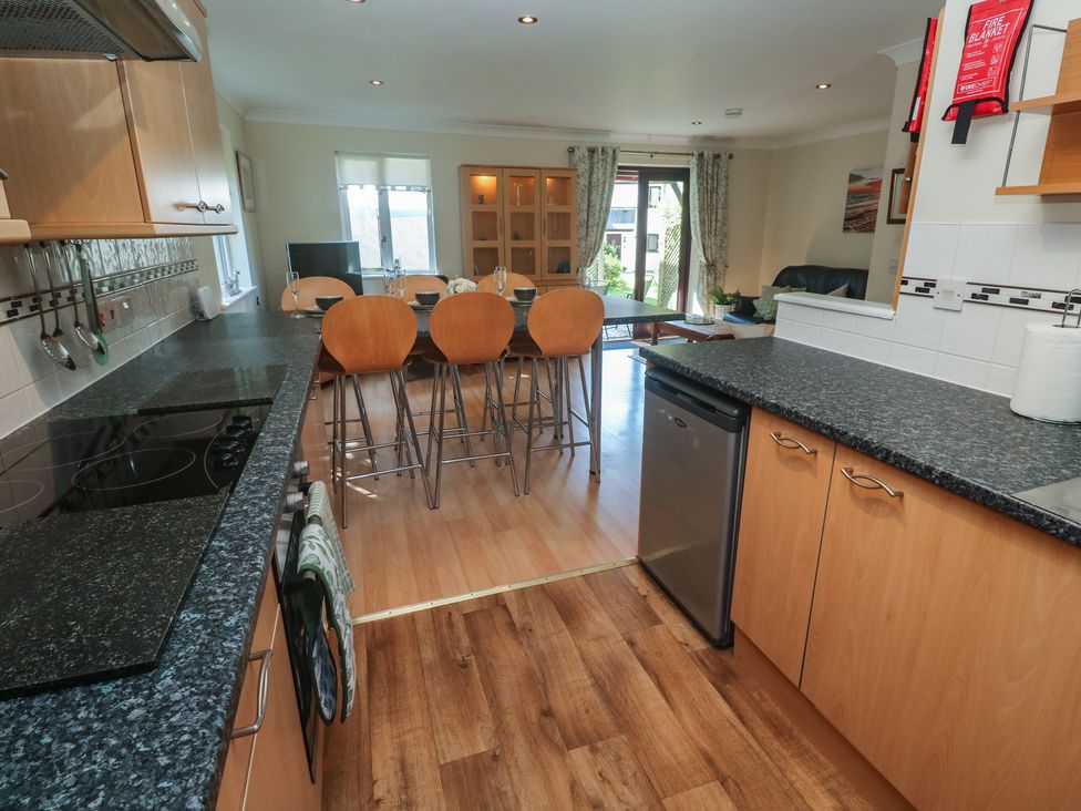 A kitchen with stools and a dining table at Stargazy in Falmouth