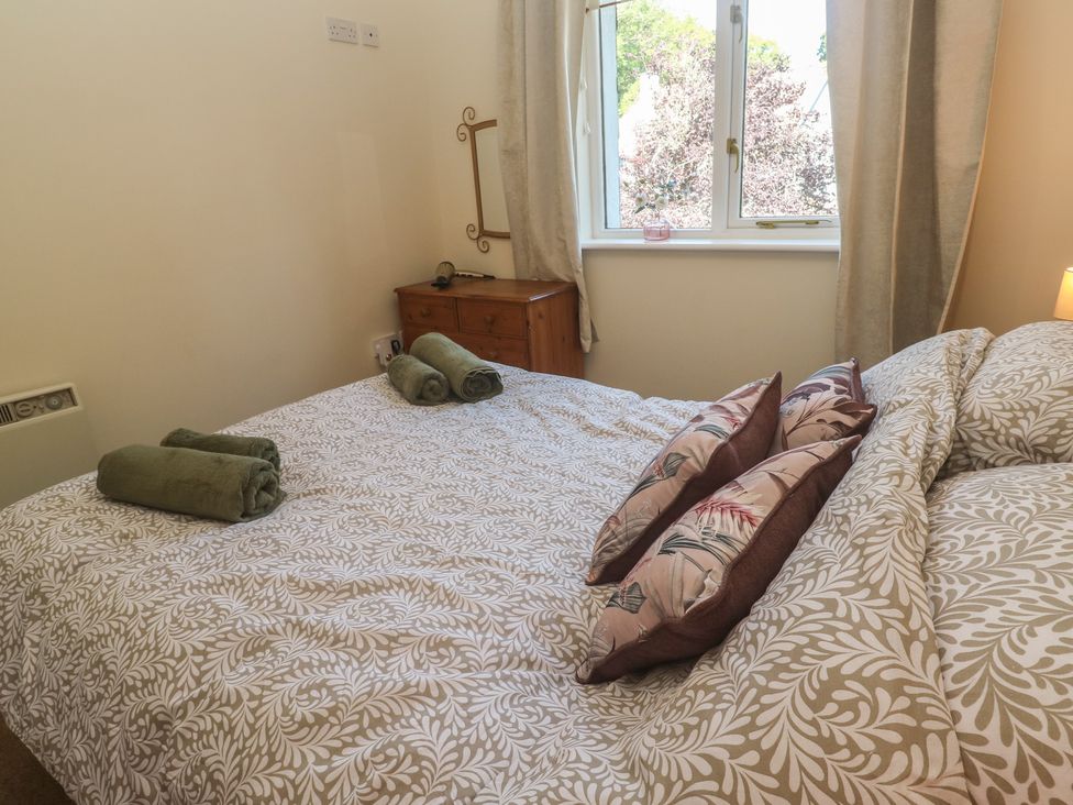 A bedroom with a bed and towels at Stargazy in Falmouth