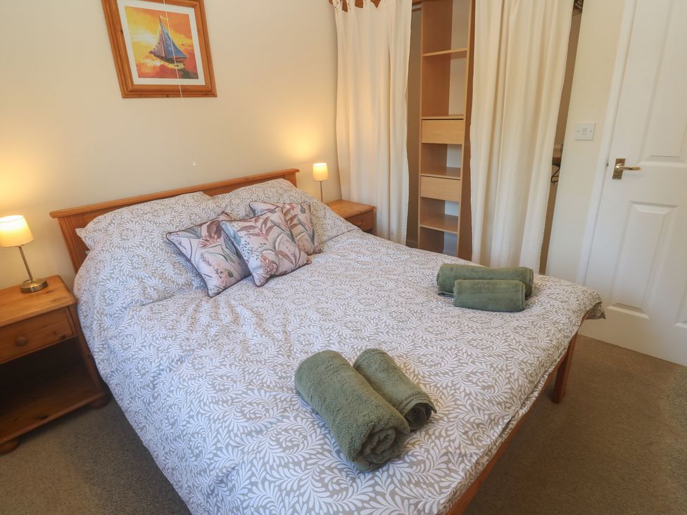 A bedroom with a bed and bedside lamps at Stargazy in Falmouth