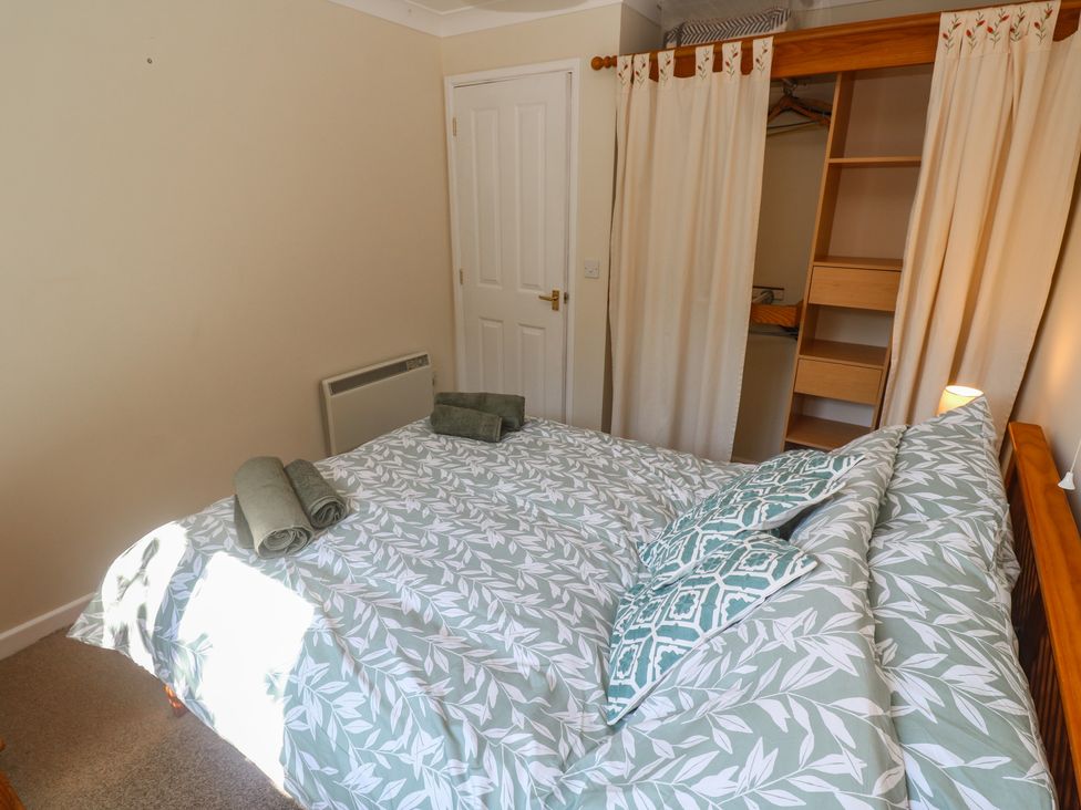 A bedroom with a bed and towels at Stargazy in Falmouth