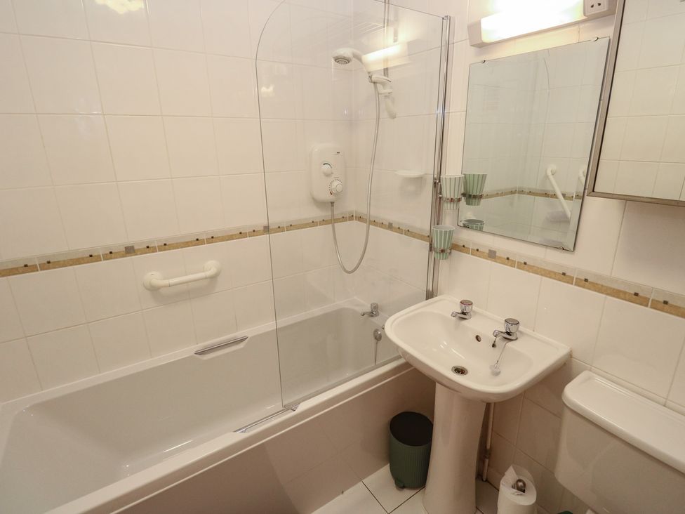 A bathroom with a bathtub, shower, sink, and toilet at Stargazy in Falmouth