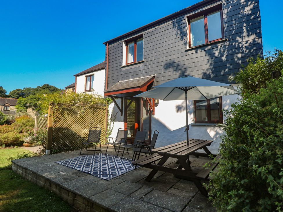 A garden with a seating area and a house at Stargazy in Falmouth