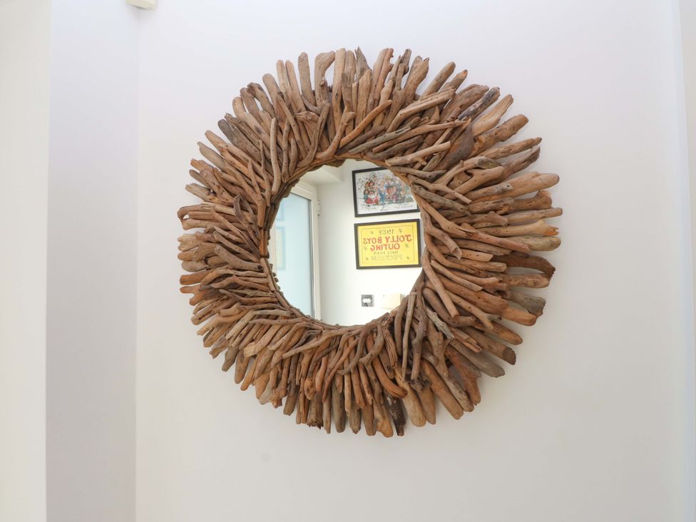 A circular driftwood mirror on the wall at 1 Marina View in Pwllheli