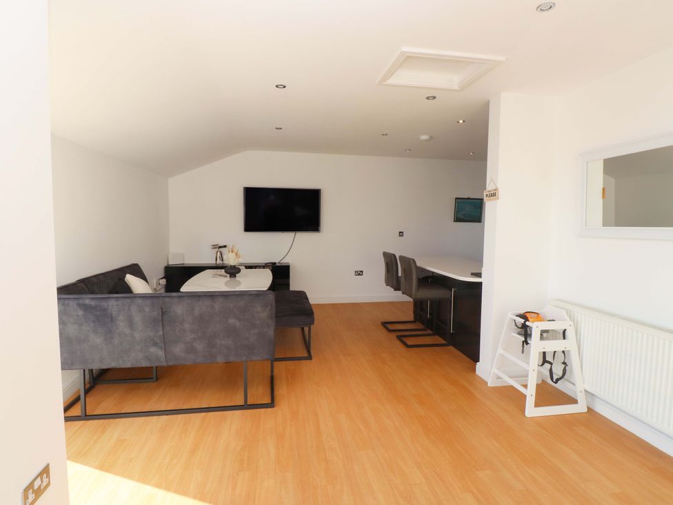 A living room with a sofa and television at 1 Marina View in Pwllheli