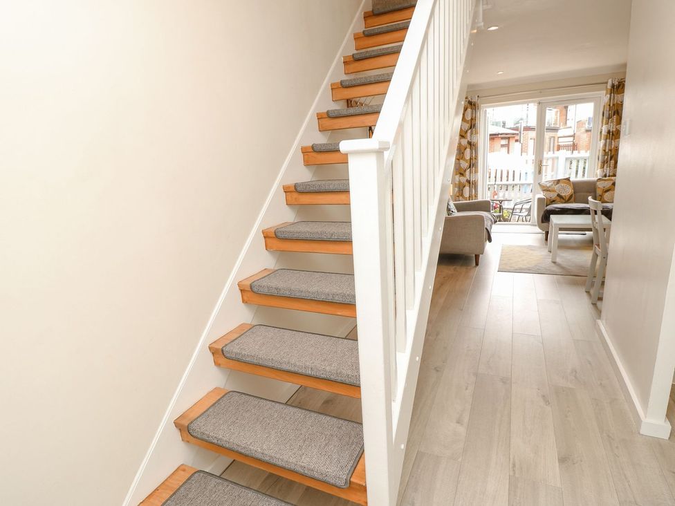 A staircase with carpeted steps leading to a living area at Harbour View Poole