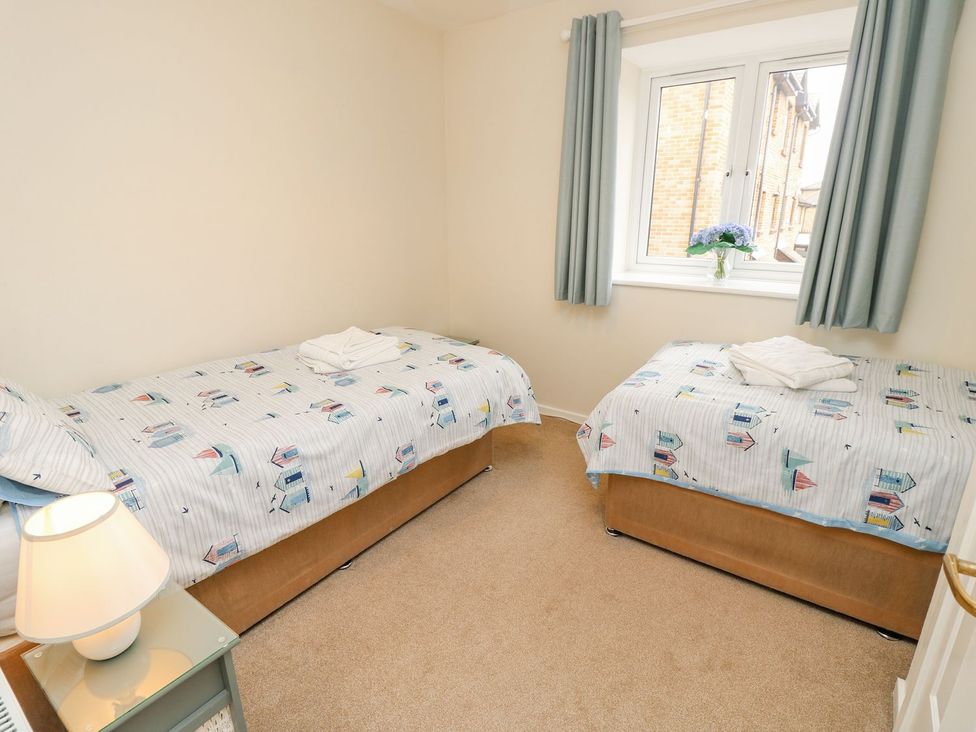 A bedroom with two beds and a window at Harbour View Poole in Poole