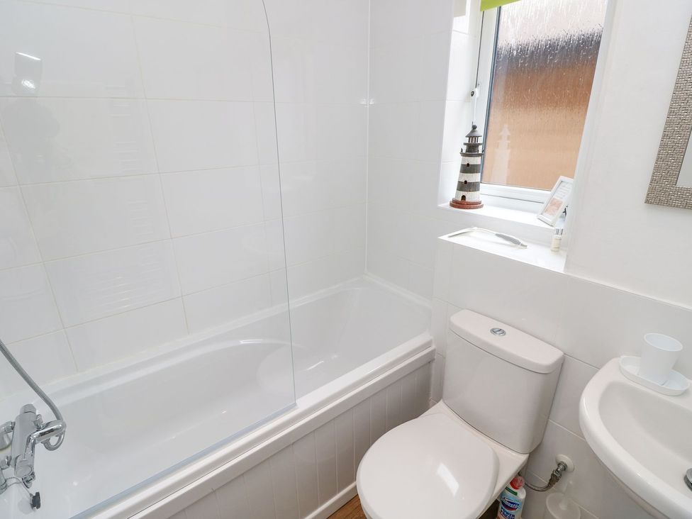 A bathroom with a bathtub and toilet at Harbour View Poole