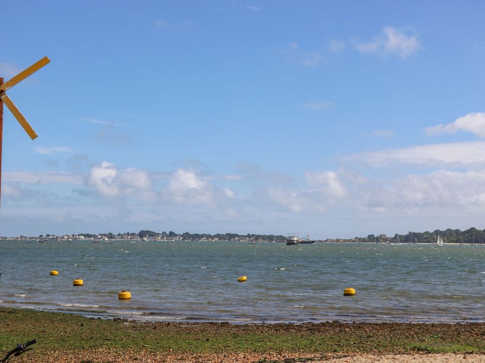 An outdoor view with a windmill and boats on the water at Harbour View Poole