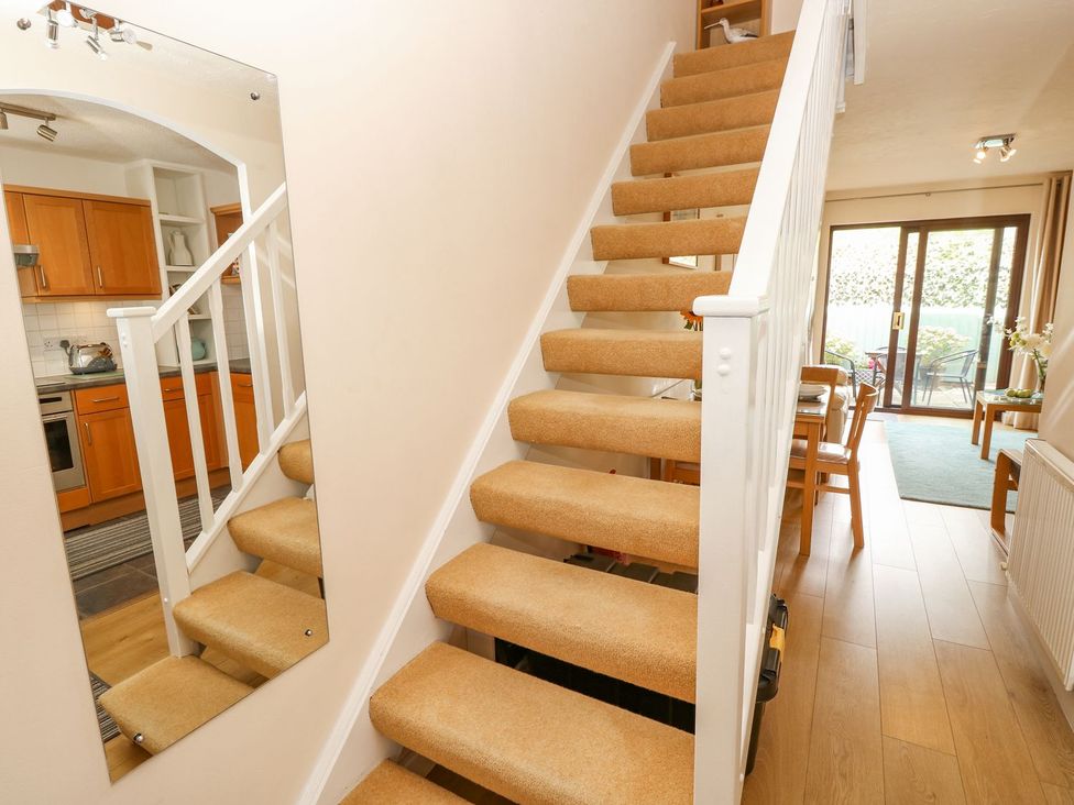 A staircase leading to upper floors with kitchen visible at Poole Quay Cottage in Poole