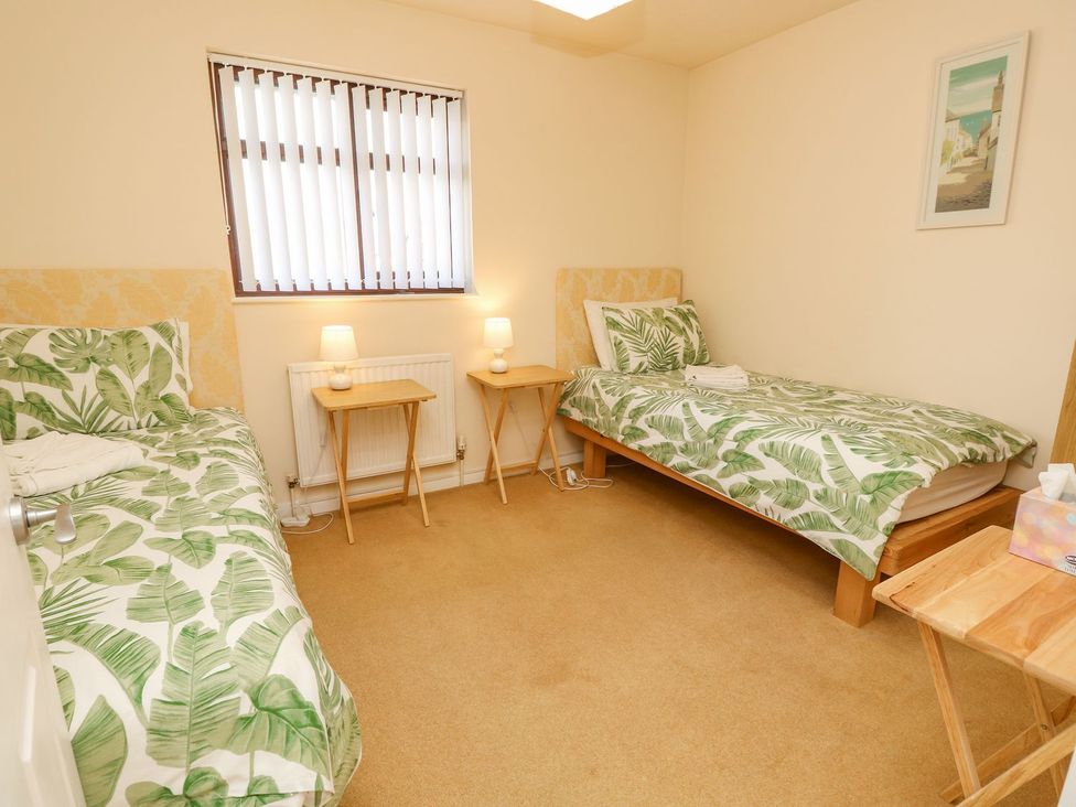 A bedroom with two beds and nightstands at Poole Quay Cottage in Poole