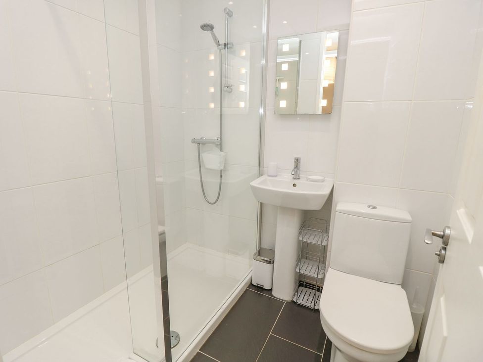 A bathroom with shower, toilet, and sink at Poole Quay Cottage in Poole