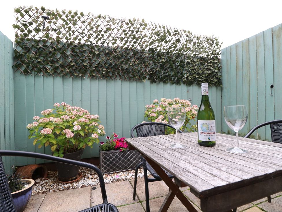 A garden with a table and wine at Poole Quay Cottage in Poole