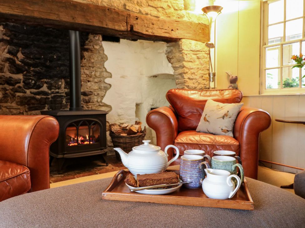 A living room with a fireplace and tea set at Manor Farm Cottages in Loughton, Milton Keynes