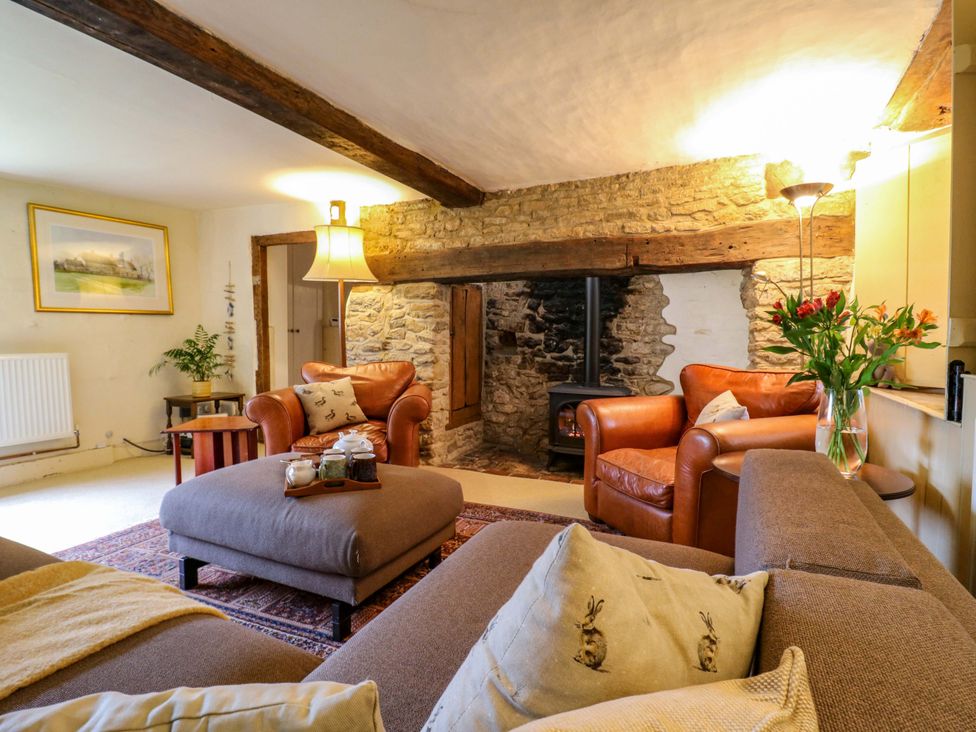 A living room with a fireplace and seating area at Manor Farm Cottages, Loughton, Milton Keynes