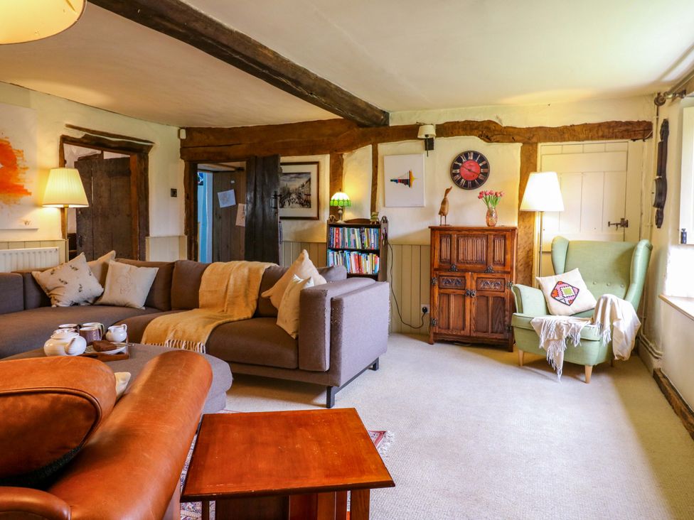 A living room with a sofa and armchair at Manor Farm Cottages in Loughton, Milton Keynes