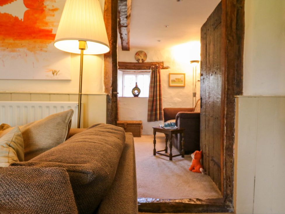 A living room with a sofa and lamp at Manor Farm Cottages in Loughton, Milton Keynes