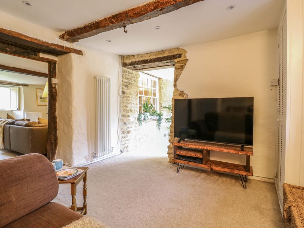 A living room with a television and a sofa at Manor Farm Cottages, Loughton, Milton Keynes