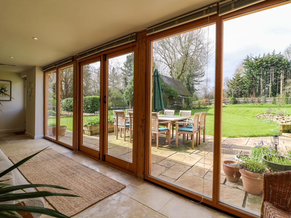 A conservatory with sliding doors overlooking the garden at Manor Farm Cottages Loughton Milton Keynes