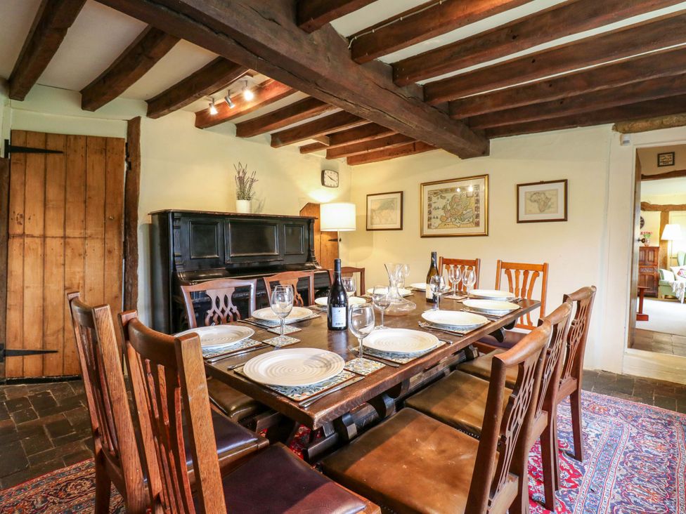 A dining room with a table set for dinner at Manor Farm Cottages in Loughton, Milton Keynes