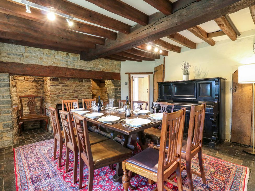 A dining room with a wooden table and chairs at Manor Farm Cottages Loughton, Milton Keynes