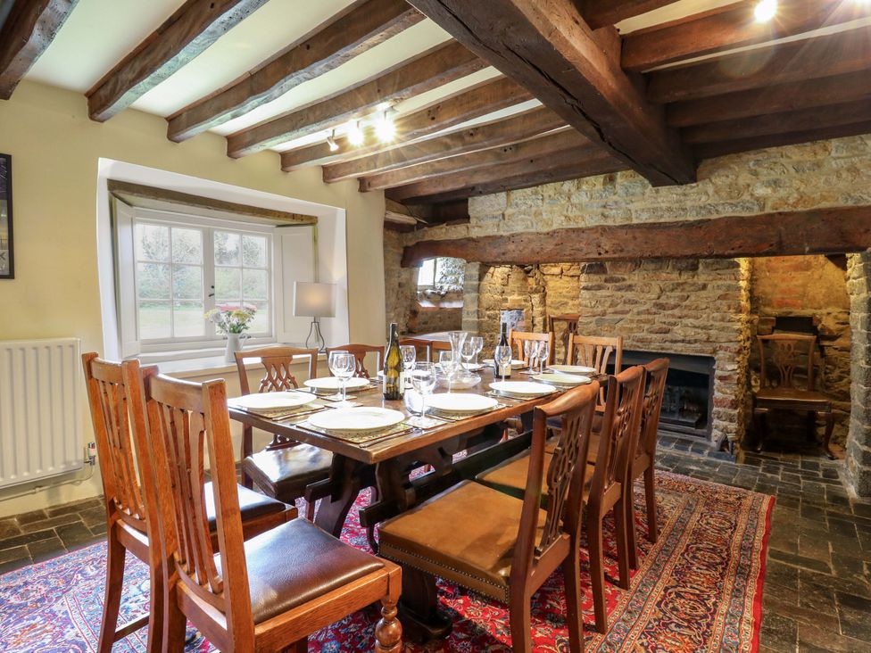 A dining room with a large table and chairs at Manor Farm Cottages, Loughton, Milton Keynes