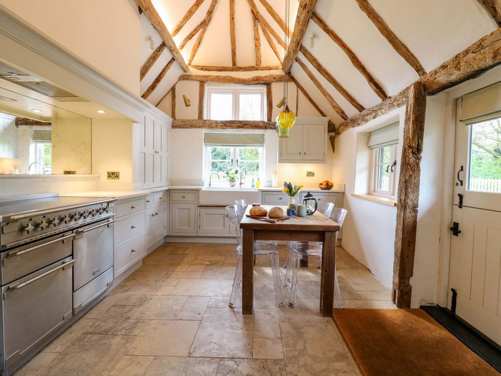 A kitchen with a table and chairs at Manor Farm Cottages in Loughton, Milton Keynes