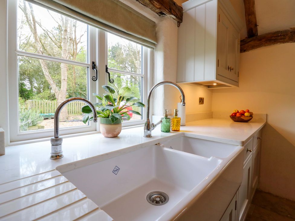 A kitchen with a sink and a window at Manor Farm Cottages in Loughton, Milton Keynes