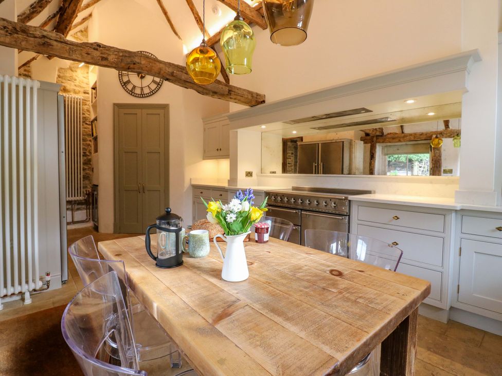 A kitchen with wooden table and chairs at Manor Farm Cottages in Loughton, Milton Keynes