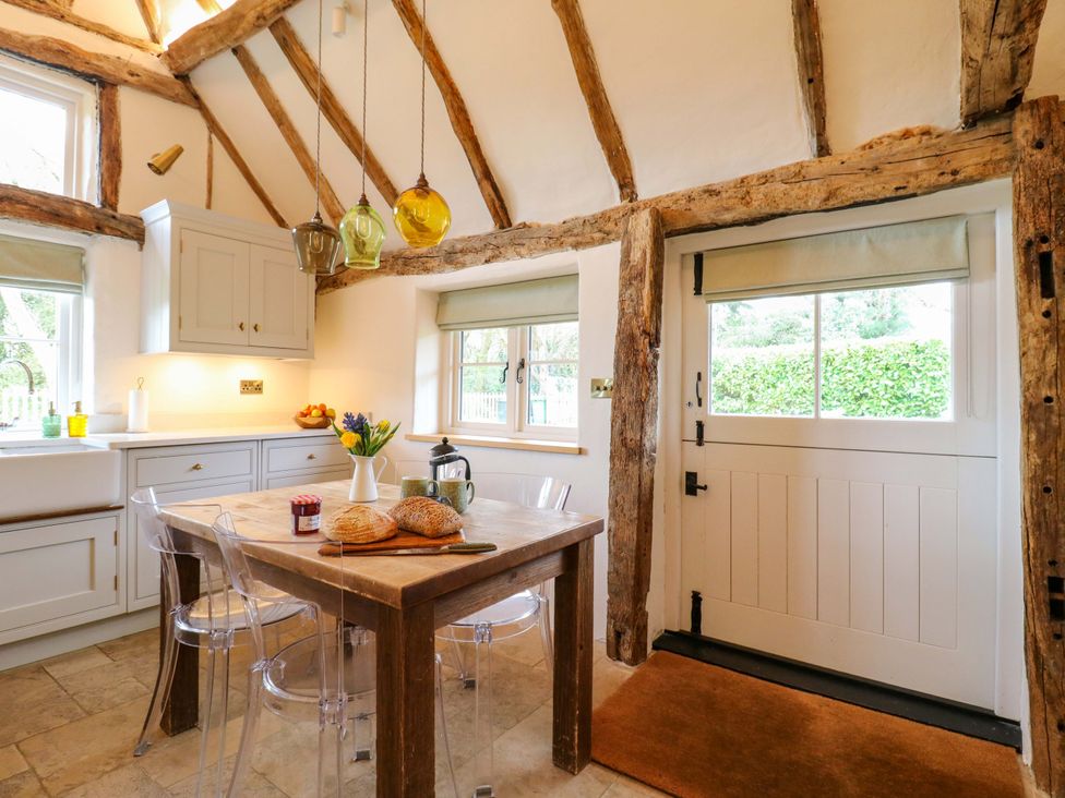 A kitchen with a table and chairs at Manor Farm Cottages in Loughton, Milton Keynes