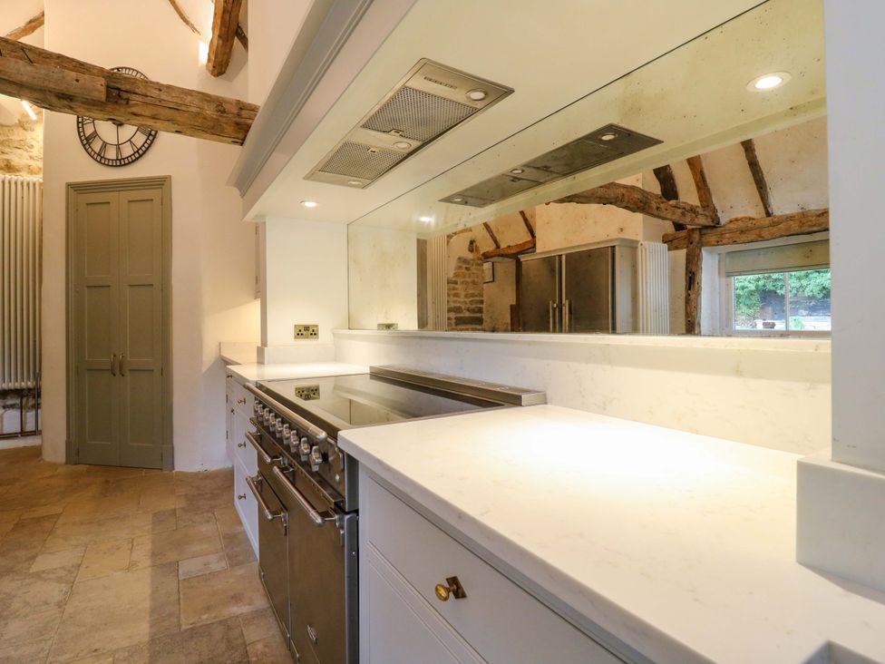A kitchen with a stove and cabinets at Manor Farm Cottages Loughton, Milton Keynes