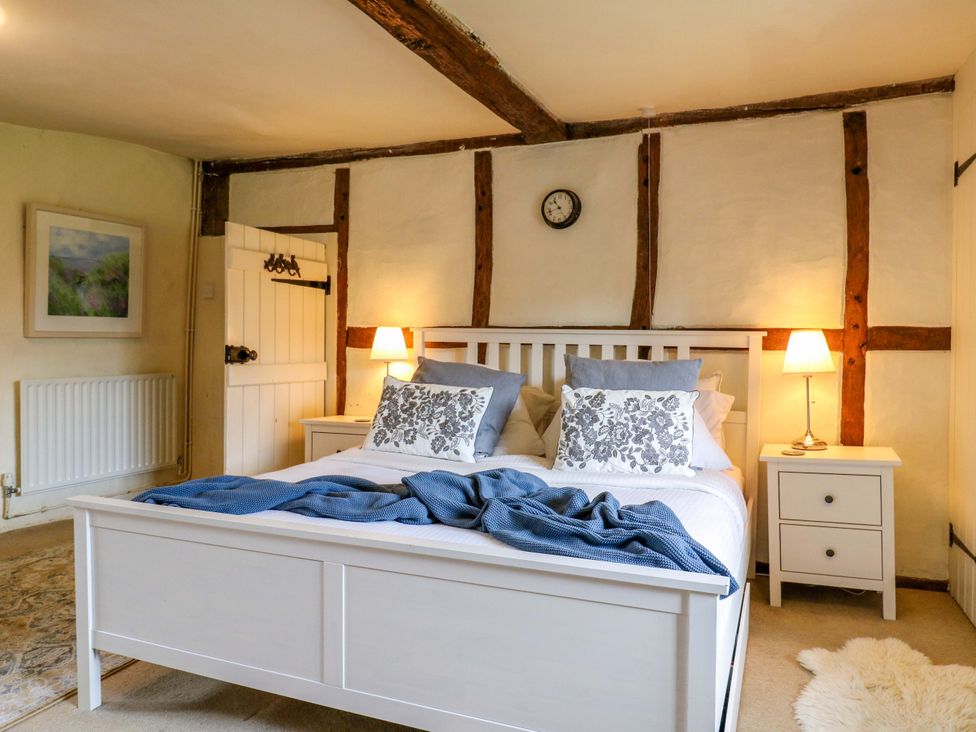 A bedroom with a bed and bedside tables at Manor Farm Cottages in Loughton, Milton Keynes
