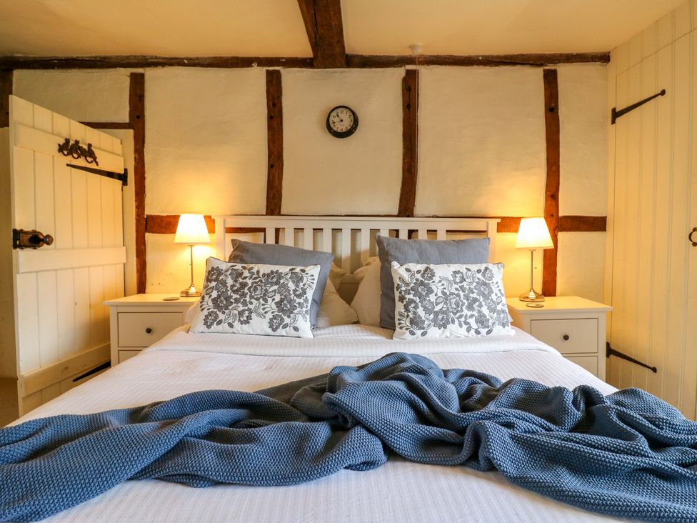 A bedroom with a bed and bedside table at Manor Farm Cottages, Loughton, Milton Keynes