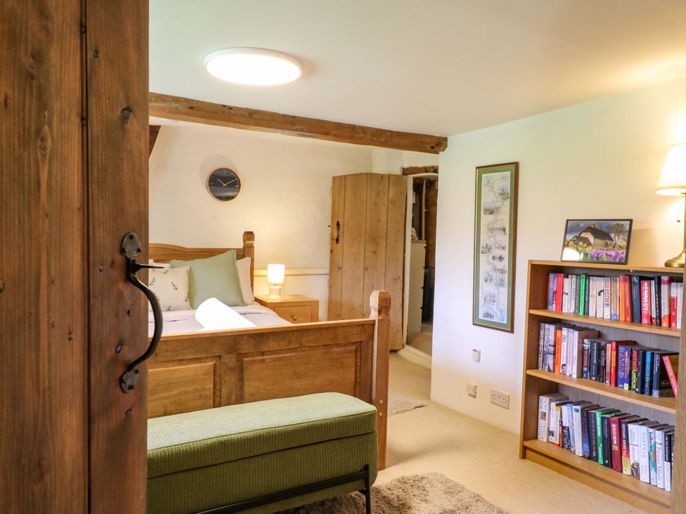 A bedroom with a bed and bookshelf at Manor Farm Cottages, Loughton, Milton Keynes