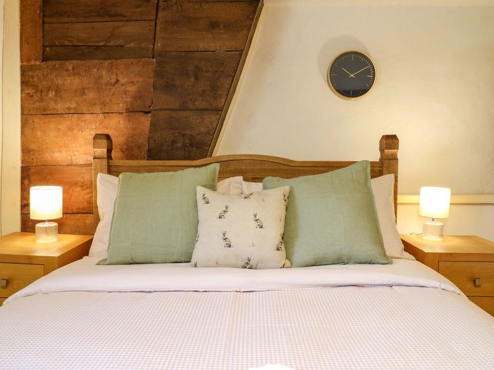 A bedroom with a bed and bedside tables at Manor Farm Cottages in Loughton, Milton Keynes