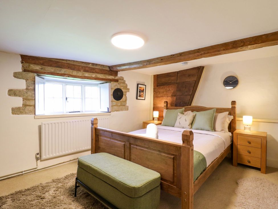 A bedroom with a bed and window at Manor Farm Cottages in Loughton, Milton Keynes