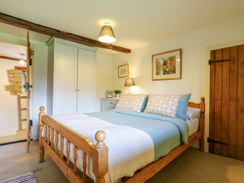 A bedroom with a bed and wardrobe at Manor Farm Cottages Loughton, Milton Keynes