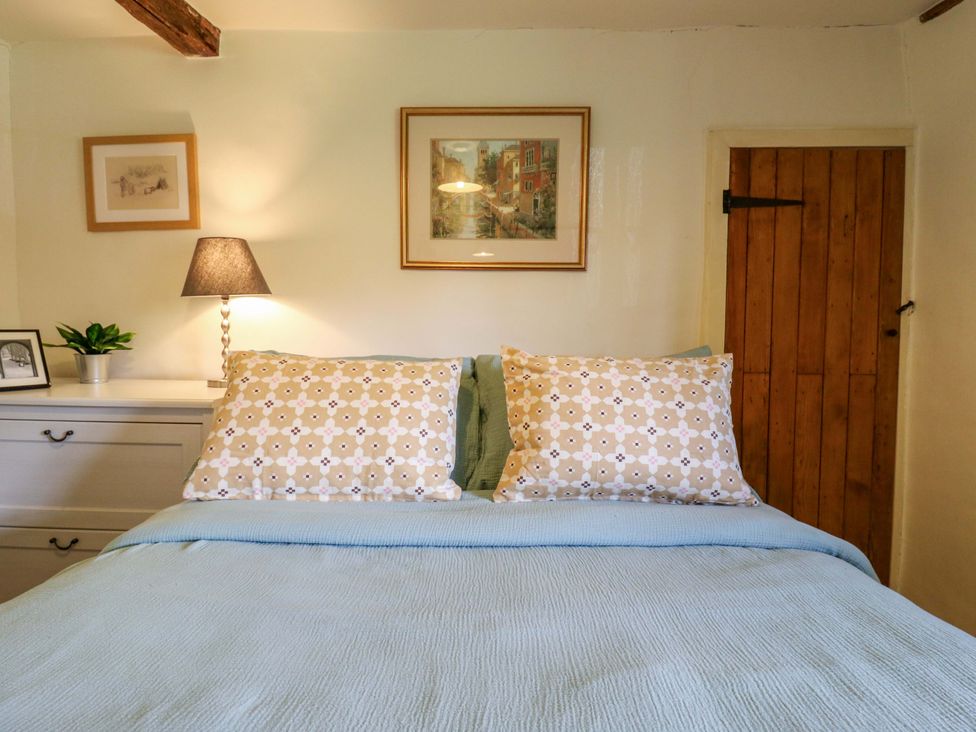 A bedroom with a bed and bedside lamp at Manor Farm Cottages, Loughton, Milton Keynes