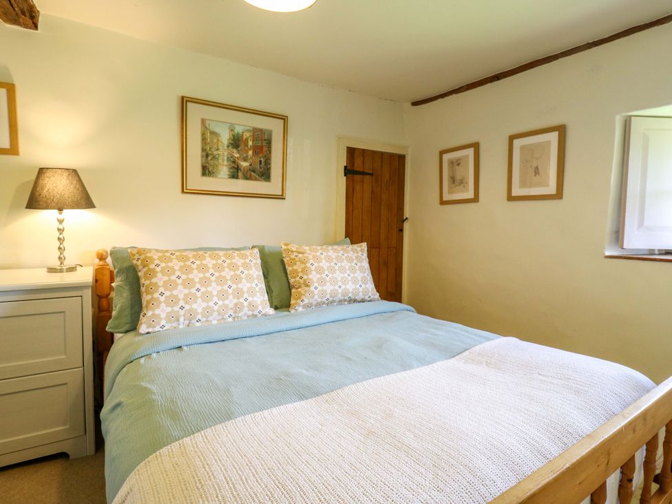A bedroom with a bed and lamp at Manor Farm Cottages in Loughton, Milton Keynes