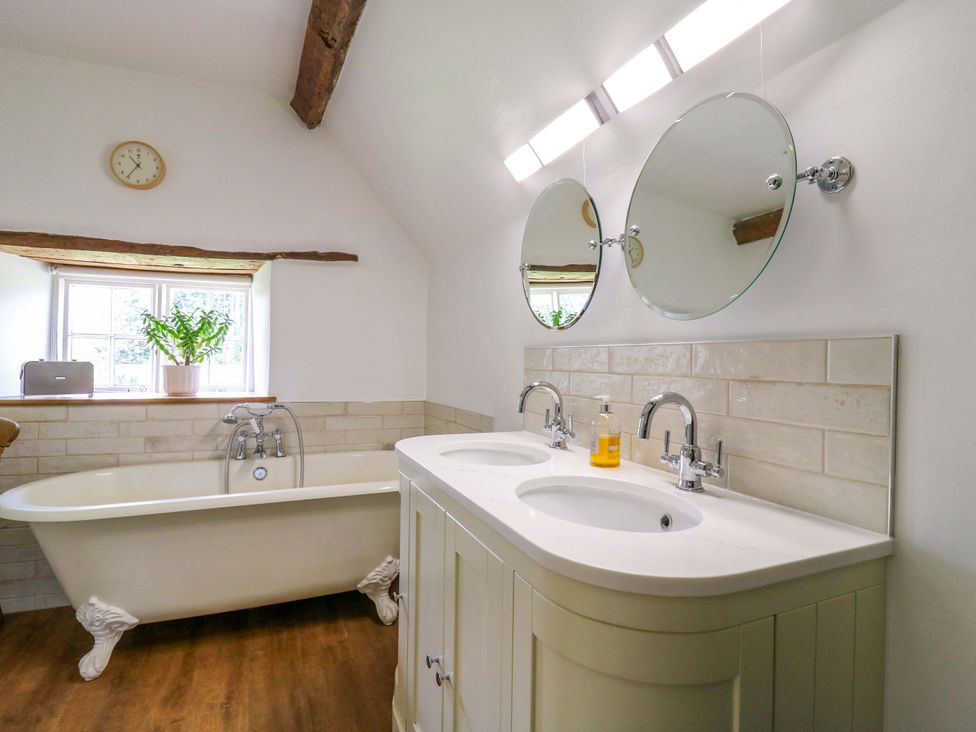 A bathroom with a freestanding tub and double sinks at Manor Farm Cottages Loughton, Milton Keynes