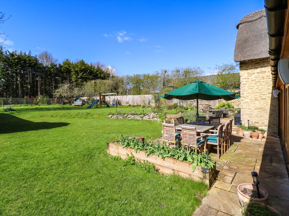 A garden with a table and chairs at Manor Farm Cottages in Loughton, Milton Keynes