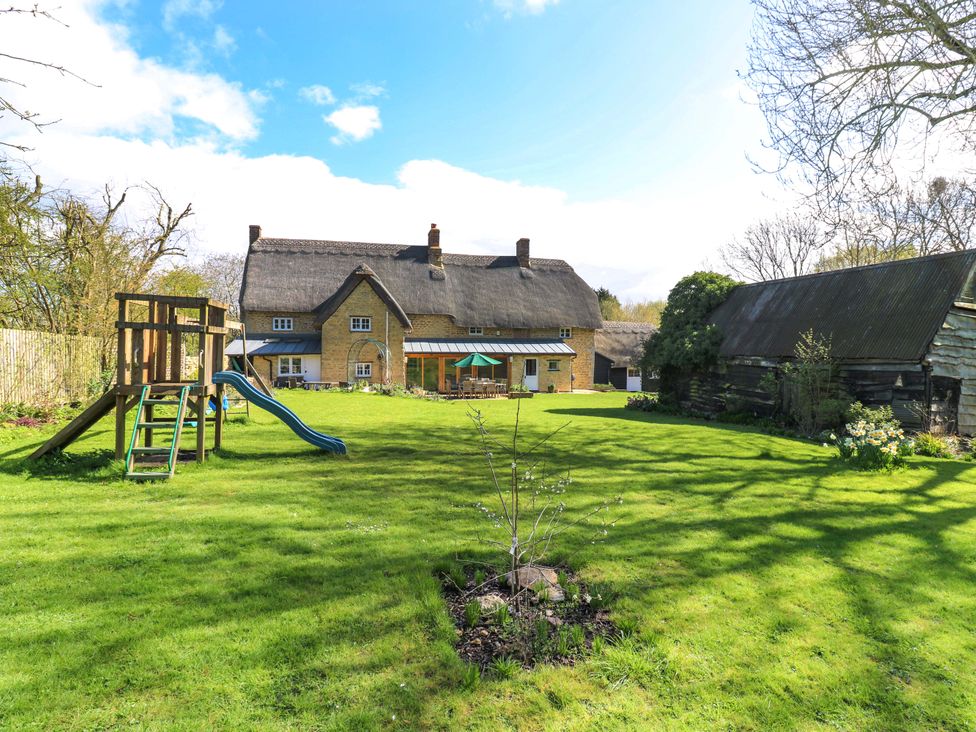 A house and playground in a garden at Manor Farm Cottages in Loughton, Milton Keynes