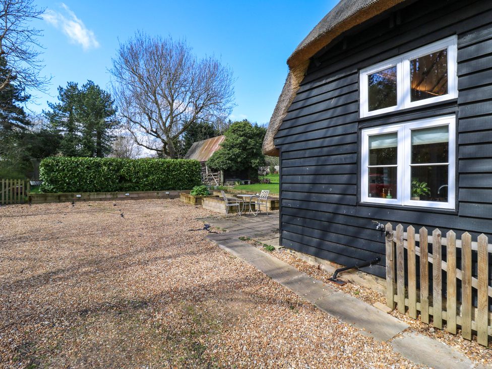 A garden with a house and outdoor furniture at Manor Farm Cottages Loughton, Milton Keynes