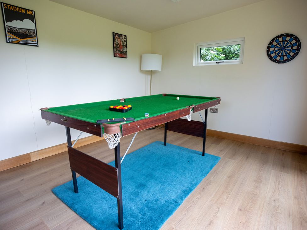 A game room with a pool table and a dartboard at Manor Farm Cottages in Loughton, Milton Keynes