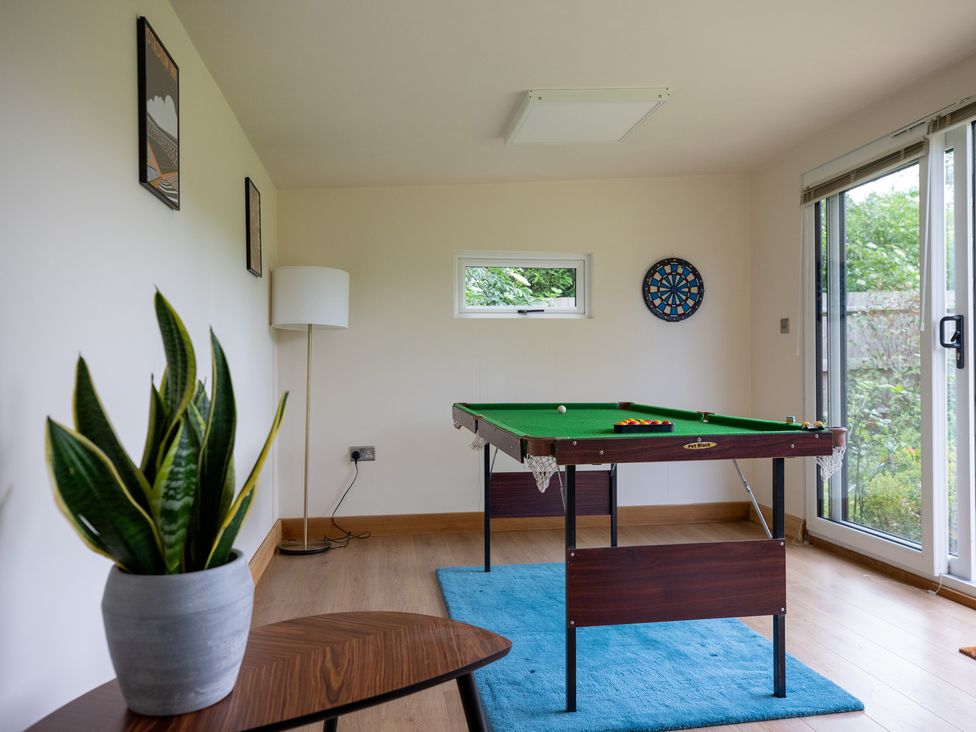 A game room with a pool table and dartboard at Manor Farm Cottages in Loughton, Milton Keynes