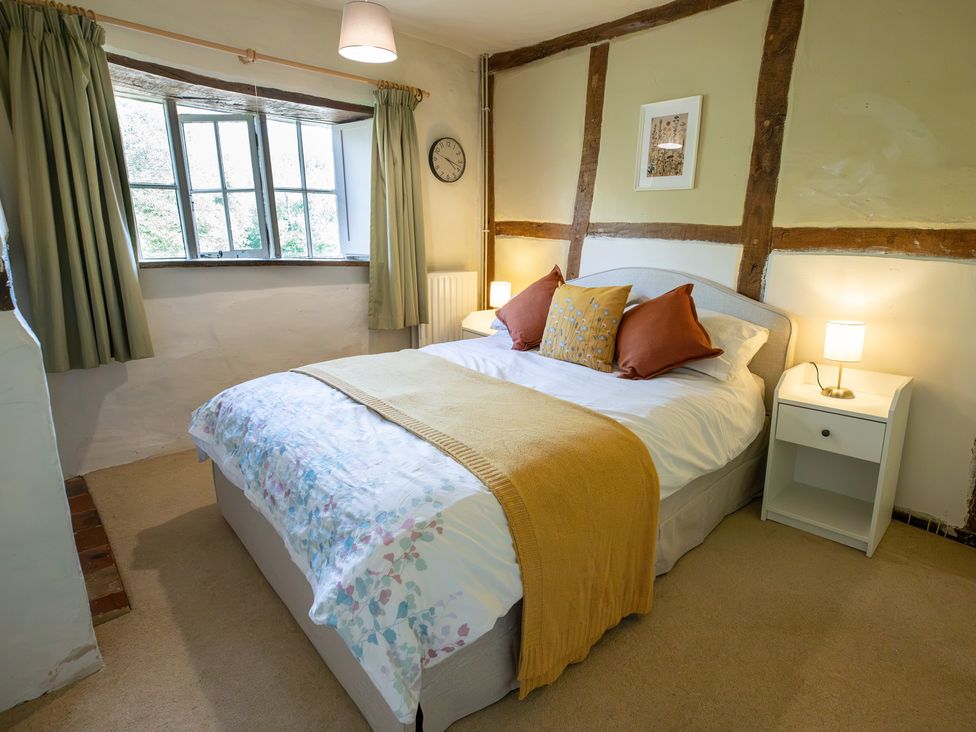 A bedroom with a bed and nightstand at Manor Farm Cottages Loughton, Milton Keynes