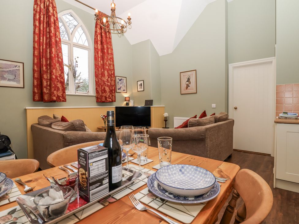 A dining room with a sofa and television at Flagstaff Cottage