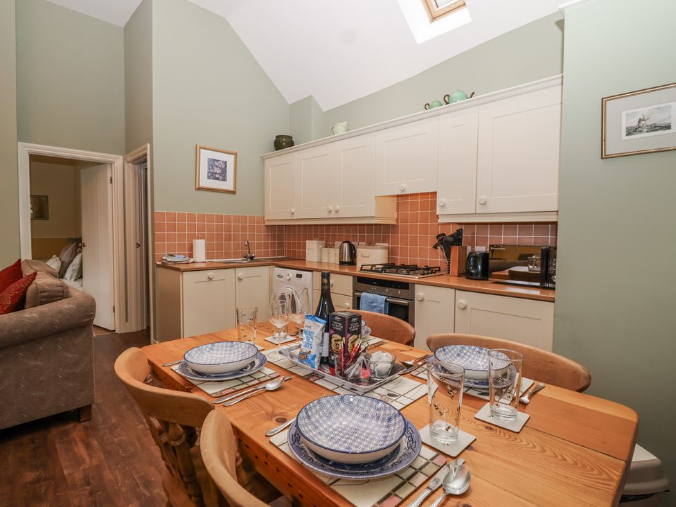 A kitchen with dining table and chairs at Flagstaff Cottage