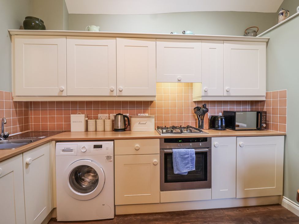 A kitchen with appliances and cabinets at Flagstaff Cottage