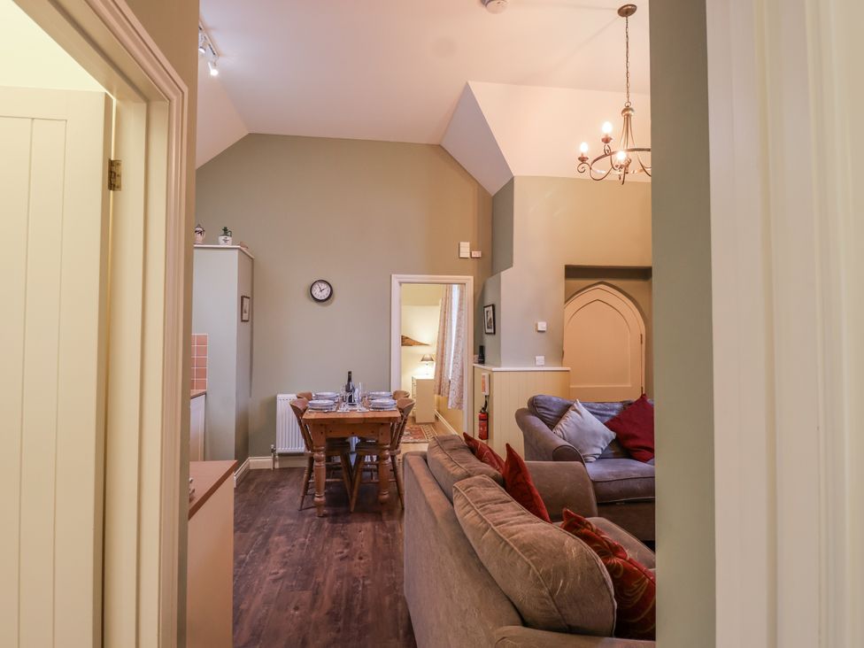 A living room with a table and chairs at Flagstaff Cottage