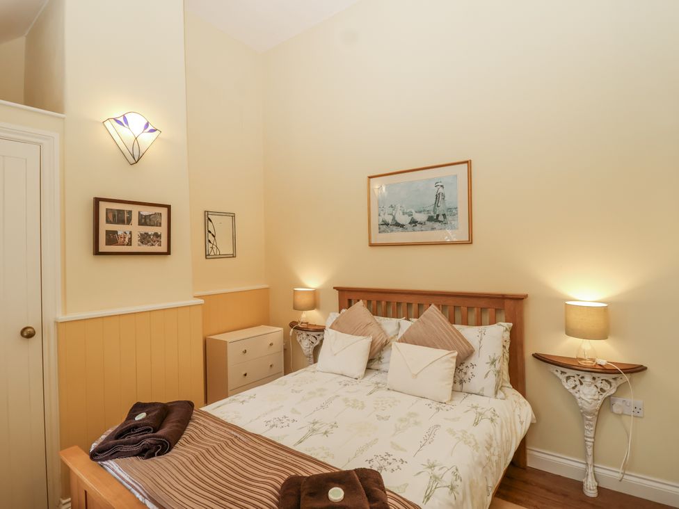 A bedroom with a bed and artwork at Flagstaff Cottage
